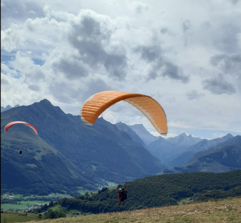 des parapentes dans un ciel de montagnes