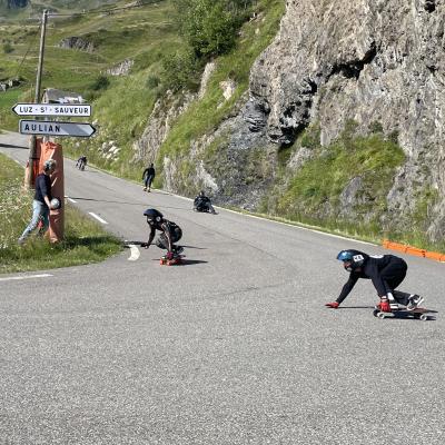 Des skaters dans un virage de la route qui descend de la station