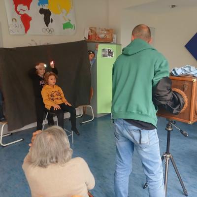 Photo pendant une prise photographique du stage avec les enfants, la vieille dame et le photographe