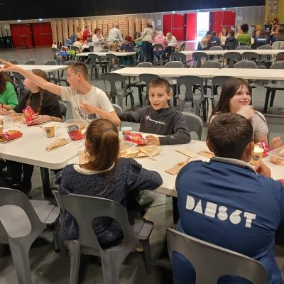 des jeunes assis à des tables en train de manger.