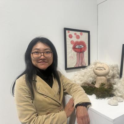 Femme devant des oeuvres d'art (bouche avec des yeux, perruques, mousses végétales