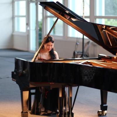 Une pianiste jouant sur un piano à queue Steinway (au premier plan)