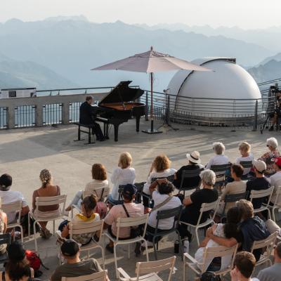 vue d'un concert au pic du midi avec des spectateurs face à un musicien jouant sur un piano à queue.