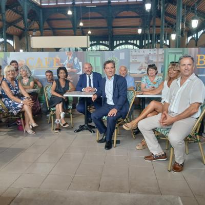 des personnes à des tables de bistro dans une  halle gourmande