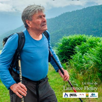 Portrait en pied ou presque de Patrice de Bellfon en randonnée dans un paysage de montagne verdoyant