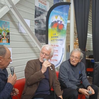 trois personnes assises sur un sofa discutent en tenant des micros