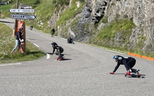 Des skaters dans un virage de la route qui descend de la station