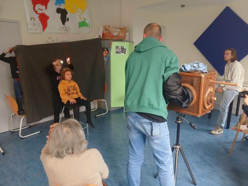 Photo pendant une prise photographique du stage avec les enfants, la vieille dame et le photographe
