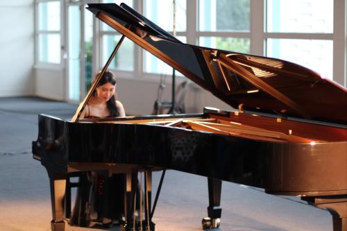 Une pianiste jouant sur un piano à queue Steinway (au premier plan)