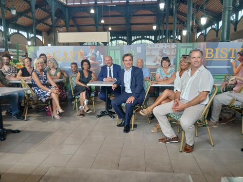 des personnes à des tables de bistro dans une halle gourmande