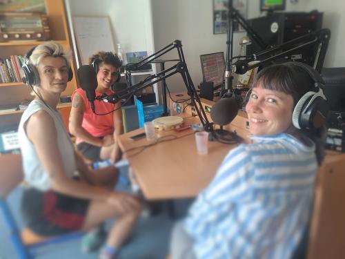 3 chanteuses sourient à la caméra dans le studio radio de Luz