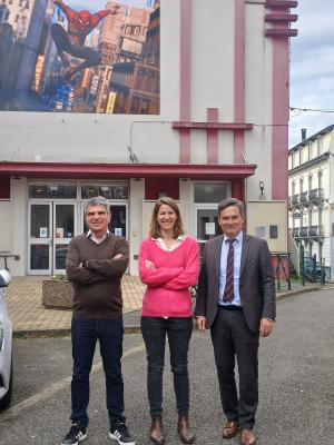 3 personnes devant un cinéma avec Spiderman au-dessus d'eux