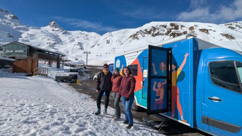 devant le bus de la Maison de la famille itinérante. 