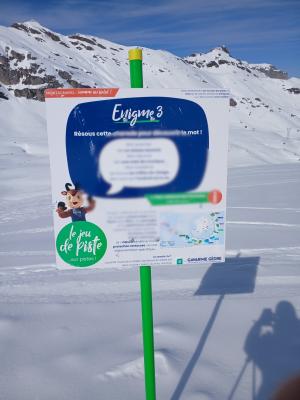 Un panneau avec des questions planté dans la neige avec vue sur les montagnes des pyrénées en arrière-plan